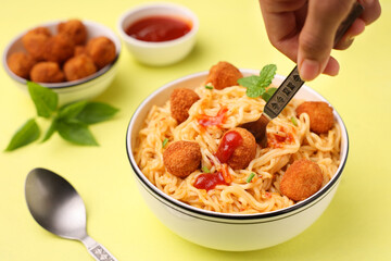 woman eating spicy asian noodles with chicken popcorn balls chicken nuggets bites instant noodles fast food meals with ketchup tomato sauce , fried snack appetizer lean meat balls kids favorite food