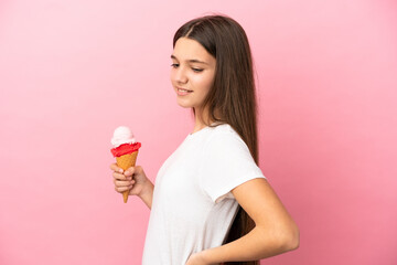 Little girl with a cornet ice cream over isolated pink background suffering from backache for having made an effort