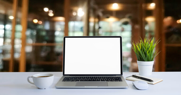 Front view of open laptop computer notebook with blank monitor white screen display on work table desk. Workspace office modern for job business online communication technology in shop or home indoor.