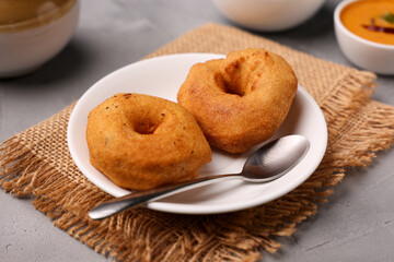 Medu Vada with tiffin sambar coconut chutney  savoury fried snack of Kerala, Tamil Nadu South Indian India Sri Lanka . Top view of Indian vegetarian veg breakfast food. Lankan food.
