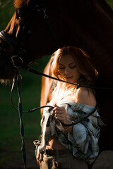 Obraz na płótnie Canvas Portrait of girl inplaid shirt with black horse in the horse farm.