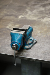 Small vise on a metal table.