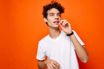 handsome man white t-shirt hand gestures emotions orange background