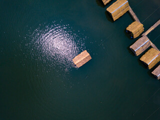 Scenery bamboo raft cottages on the lake with sunshine reflect on water. Summer vacation destinations. Aerial view or top view