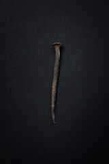 Old nail on black background