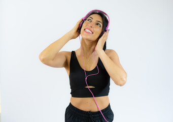 Fitness woman in sportswear and headphones listening music isolated over white background.