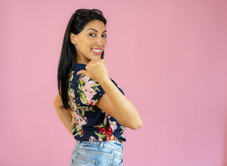 Smiling woman with thumb up over pink background.