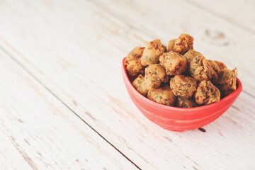 Indian traditional snack spicy Pakoda on wooden table	
