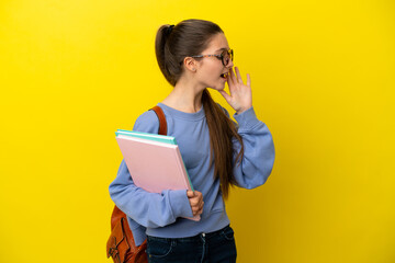 Student kid woman over isolated yellow background shouting with mouth wide open to the side