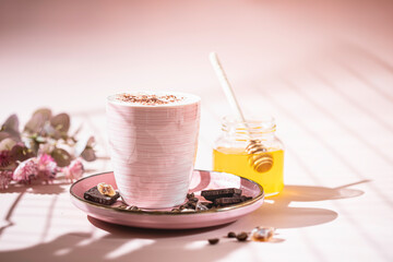 Cappuccino or latte with honey in ceramic dishes. Coffee with milk foam. Coffee, honey, milk and coffee beans.