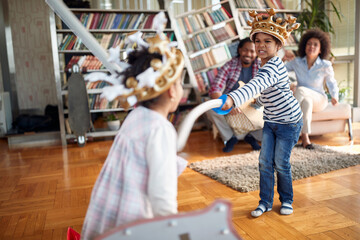 Kids are excited playing with swords while parents cheer. Family, together, love, playtime