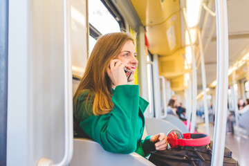 Fototapeta na wymiar young woman traveling underground talking smart phone