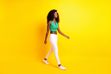 Fototapeta na wymiar Full length body size photo funky girl smiling walking forward in stylish clothes isolated vivid yellow color background