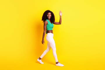 Fototapeta na wymiar Full length body size photo funky girl smiling waving hand greeting saying hello isolated bright yellow color background