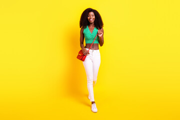 Fototapeta na wymiar Full length body size photo female student in stylish clothes walking forward smiling isolated vivid yellow color background