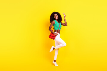 Fototapeta na wymiar Full length body size photo woman in stylish clothes showing v-sign gesture smiling isolated bright yellow color background