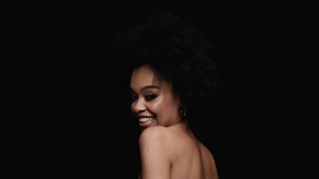 The smiling woman dancing sides and snapping fingers in a black studio