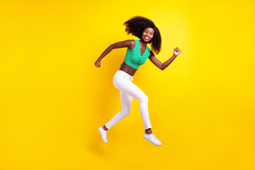 Full length body size photo young girl jumping running on meeting smiling cheerful isolated vivid yellow color background