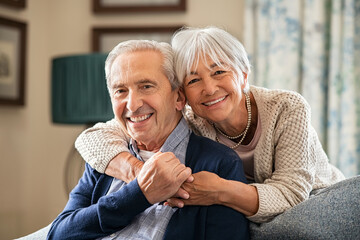 Happy senior couple embracing at home with love