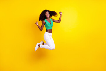 Fototapeta na wymiar Full length body size photo young girl jumping gesturing like winner isolated vibrant yellow color background