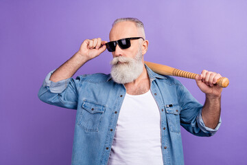 Photo of aged man serious confident hold baseball bat sportive hand touch sunglass isolated over...