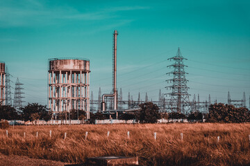 Fototapeta na wymiar High voltage Electrical substation with steel frames, insulators and electricity transmission power lines and blue sky background (cinematic camera picture profile concept)