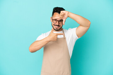 Fototapeta premium Restaurant waiter caucasian man isolated on blue background focusing face. Framing symbol