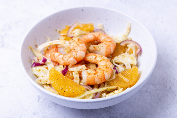 Shrimp salad with fennel, orange and red onion. Close-up, selective focus.
