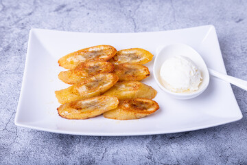 Fried bananas with honey, cinnamon, coffee and ice cream. Close-up.