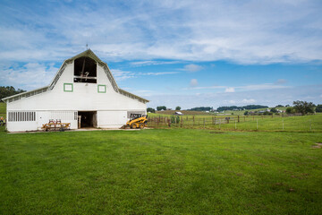 Farm barn with equipment on summer day