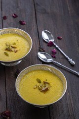 mango-flavored Phirni served in  traditional metal  bowls