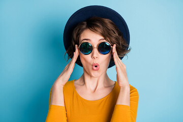 Photo portrait of amazed shocked woman in sunglass wearing shirt headwear isolated on bright blue...