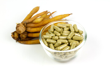 Finger root (Krachai) capsule in transparent bowl glass isolated on white background. The scientific name is Boesenbergia rotunda. Finger root is herb and Thai food ingredient.