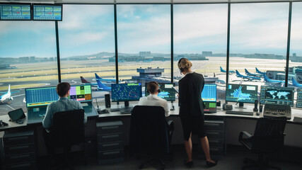 Diverse Air Traffic Control Team Working in a Modern Airport Tower. Office Room is Full of Desktop...