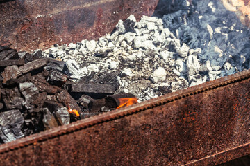 Used metal brazier with coals close-up