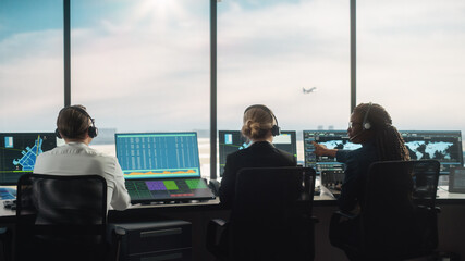 Diverse Air Traffic Control Team Working in a Modern Airport Tower. Office Room is Full of Desktop Computer Displays with Navigation Screens, Airplane Departure and Arrival Data for Controllers.