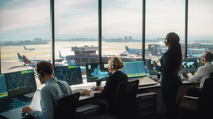 Diverse Air Traffic Control Team Working in a Modern Airport Tower. Office Room is Full of Desktop...