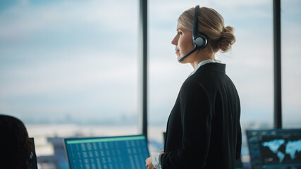 Female Air Traffic Controller with Headset Talk on a Call in Airport Tower. Office Room is Full of Desktop Computer Displays with Navigation Screens, Airplane Flight Radar Data for the Team. © Gorodenkoff