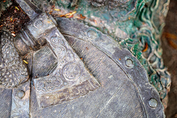 viking ax lies on the shield of a fallen warrior close-up