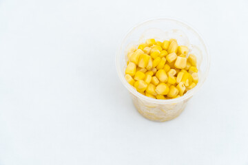 Tinned corn in a plastic cup isolated on white
