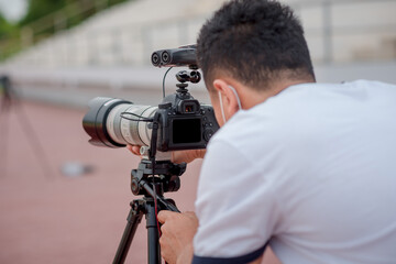 The photographer is setting up his camera to take pictures.