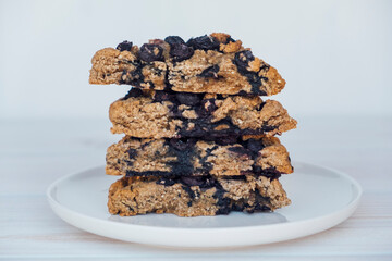 Homemade oatmeal scones with berries stacked on white plate. Vegan sweet baked food. Gluten free pastry.