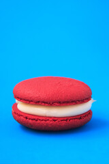 red Cake macaron or macaroon on blue background.