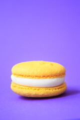 yellow Cake macaron or macaroon on purple background.