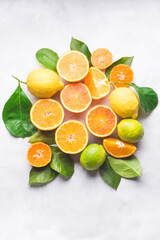 Group of various citrus fruits on the  white background. Oranges, oranges Tarocco, lime, lemon and mandarins with green leaves.  Healthy food and drinks concept. Organic citrus fruits