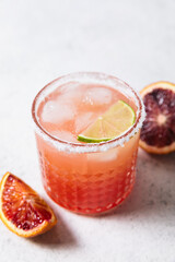 Blood orange margarita cocktail on white table background. Summer cocktails, refreshing drinks, cocktail party concept. Copy space