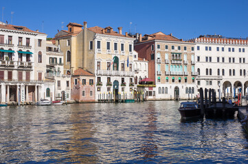 Fototapeta na wymiar facades facing blue clean waters of busy grand canal of Venice
