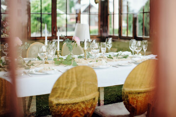 Festive table setting for a birthday or wedding in rustic, boho style, photographed through glass. Decor in natural colors. Selective focus.