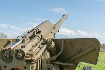 A large green cannon from the Second World War at the open-air memorial complex. Artillery gun.