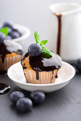 Homemade vanilla muffins with chocolate sauce and fresh summer berries